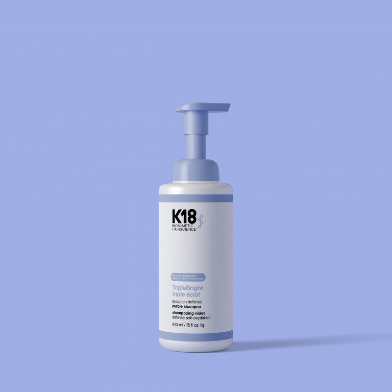 K18 Triple Bright Shampoo bottle on a light blue background