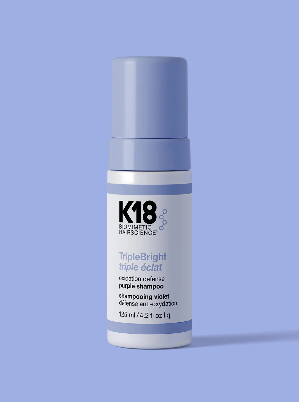 K18 purple shampoo bottle on a light blue background