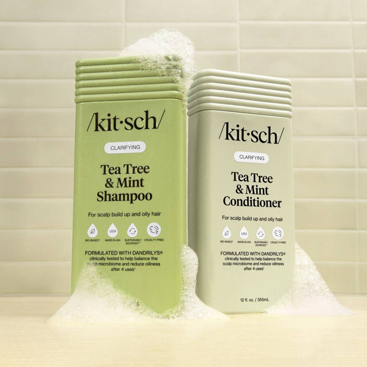 Kitsch Tea Tree & Mint Shampoo and Conditioner bottles on a tiled bathroom background